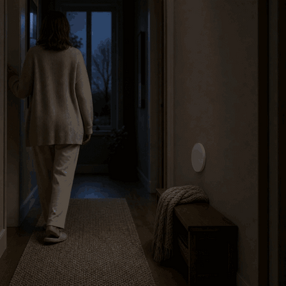 Woman walks into the dark hallway and the LumiBeam night light turns on via motion sensor