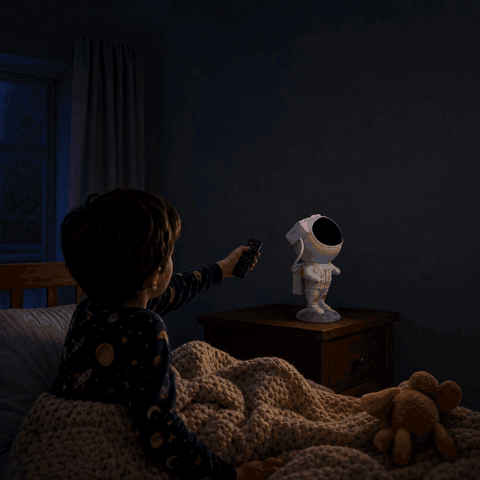 Boy switches on the Astronaut star projector with the remote control, galaxy appears on the kids room ceiling