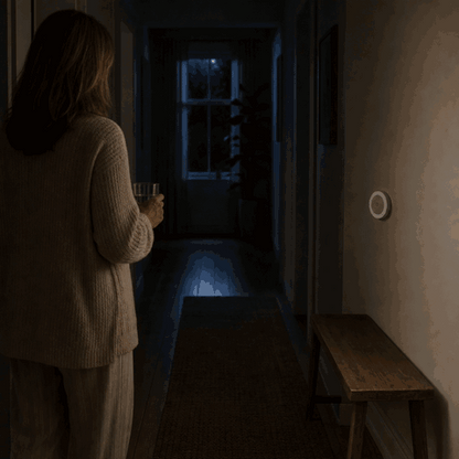 Woman enters the dark hallway and the LumiBeam night light turns on via motion sensor