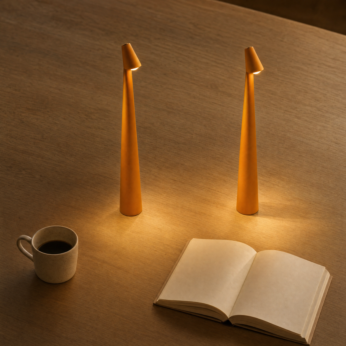 Two orange LumiNord LED table lamps on a wooden table with coffee and a book