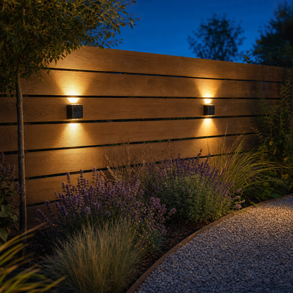 Two SolarGlow solar lights on the garden fence at dusk