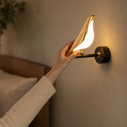 Hand turns the rotatable head of the Avia bird wall light